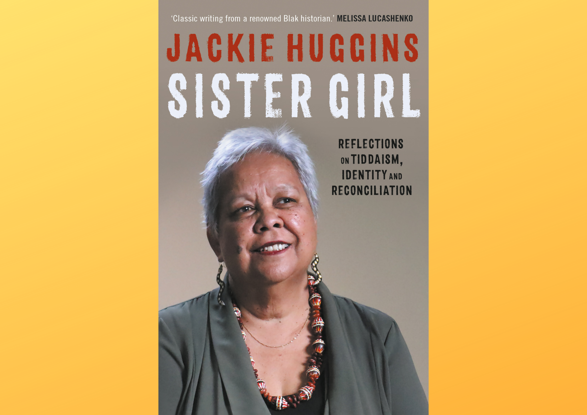 Book cover for Dr Jackie Huggins' 'Sister Girl' set against an ombre yellow background. The cover features a head shot of Dr Huggins, who has medium-brown skin and short white hair, and is wearing an olive-green blazer over a black top. She is also wearing a pair of dangling snake-shaped earrings decorated with dotwork art, and a colourful chunky necklace made of decorated large beads and small red seeds strung together. The cover also includes the book title, author name, and review by Melissa Lucashenko.
