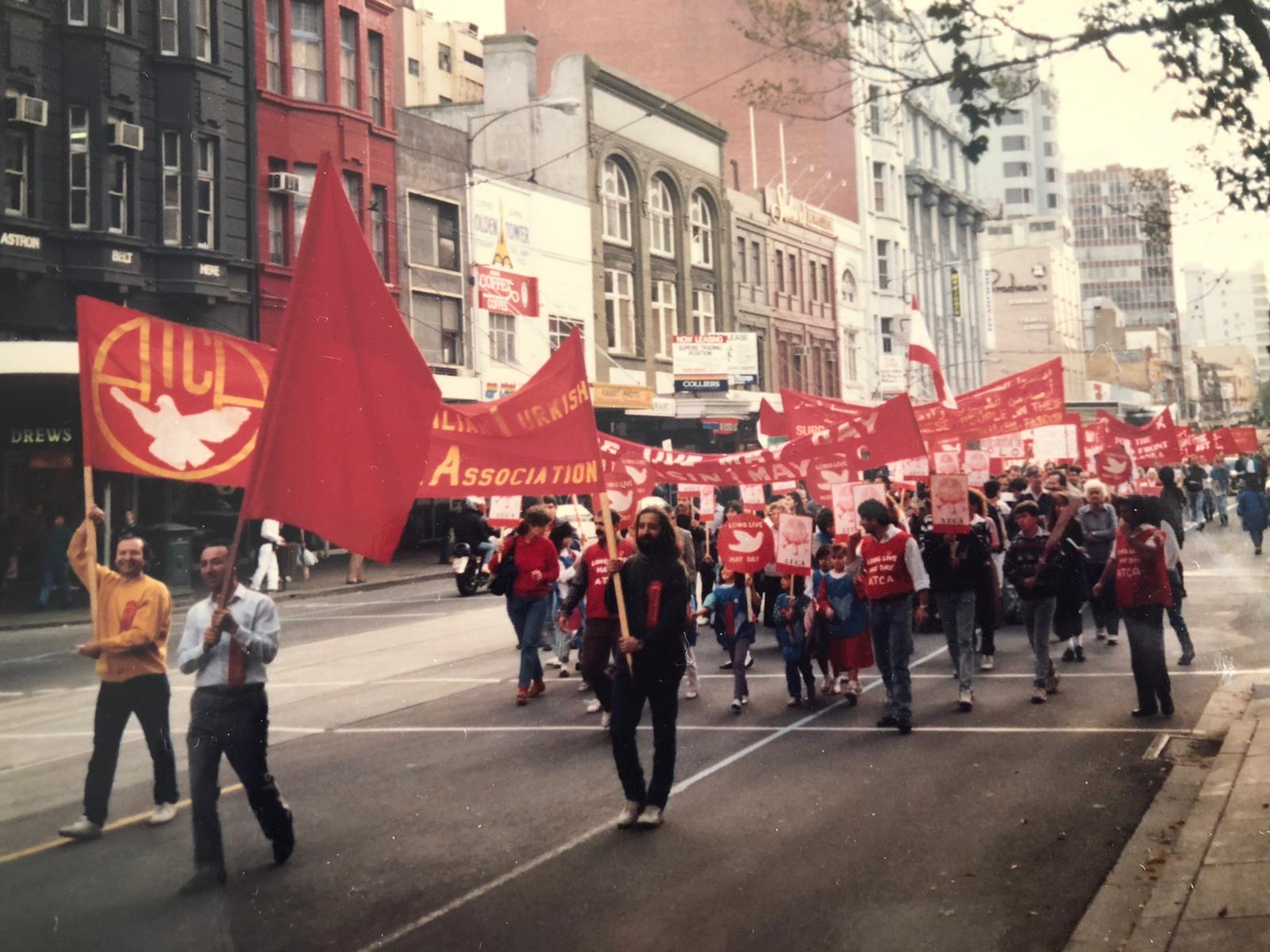 A coloured photograph showing people holding red banners as part of the Australian Turkish Cultural Association (ATCA) at the 1988 May Day march in Narrm.