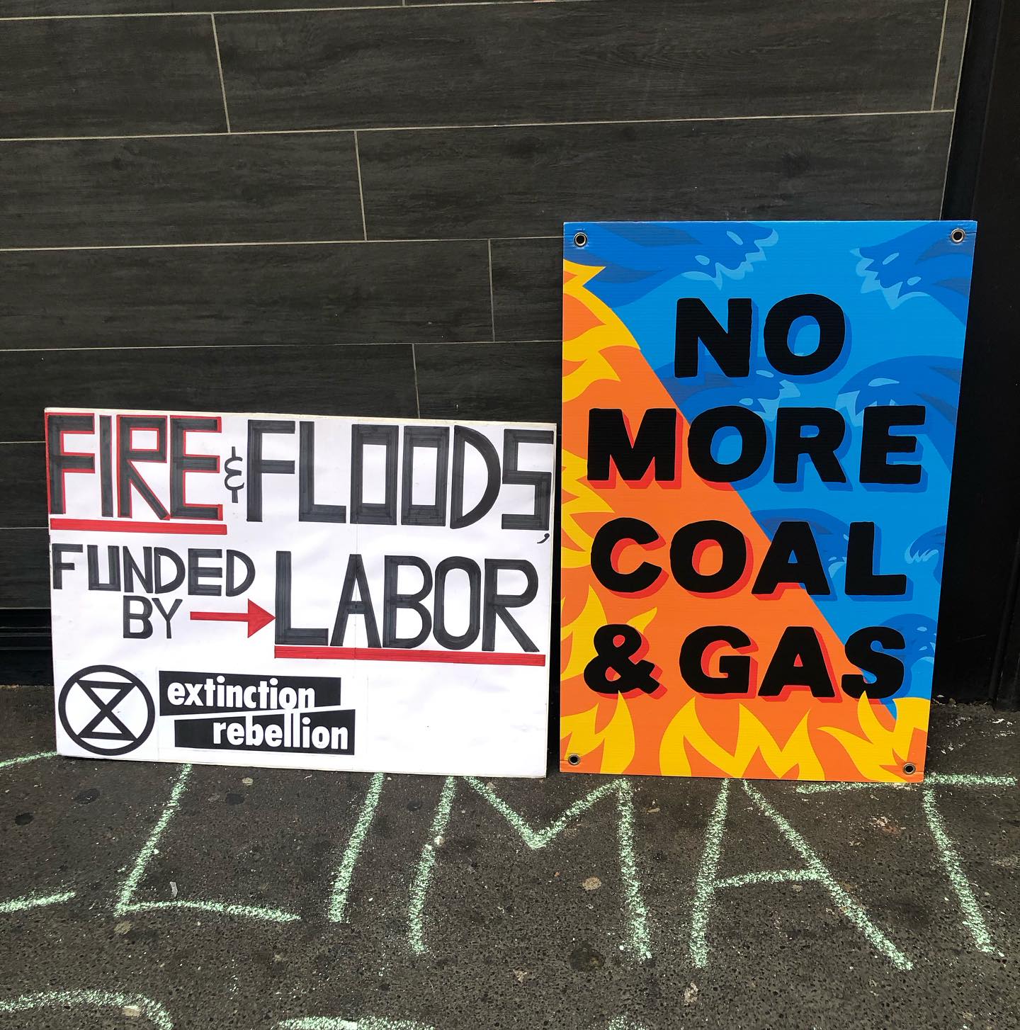 Protest signs read "no more coal & gas" and "fire and floods funded by Labor"