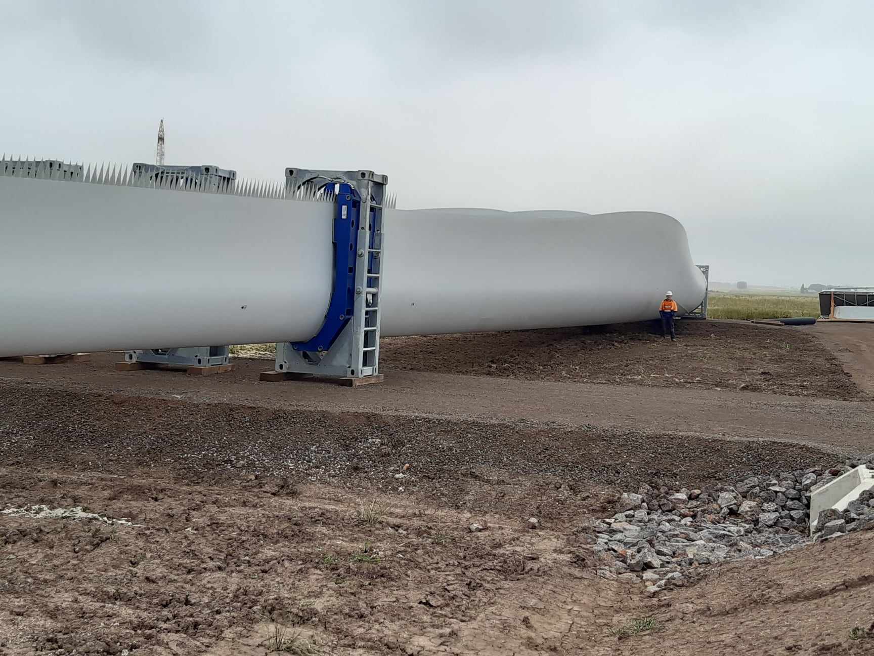 Our guest Michael standing next to the giant blade of a wind turbine. 