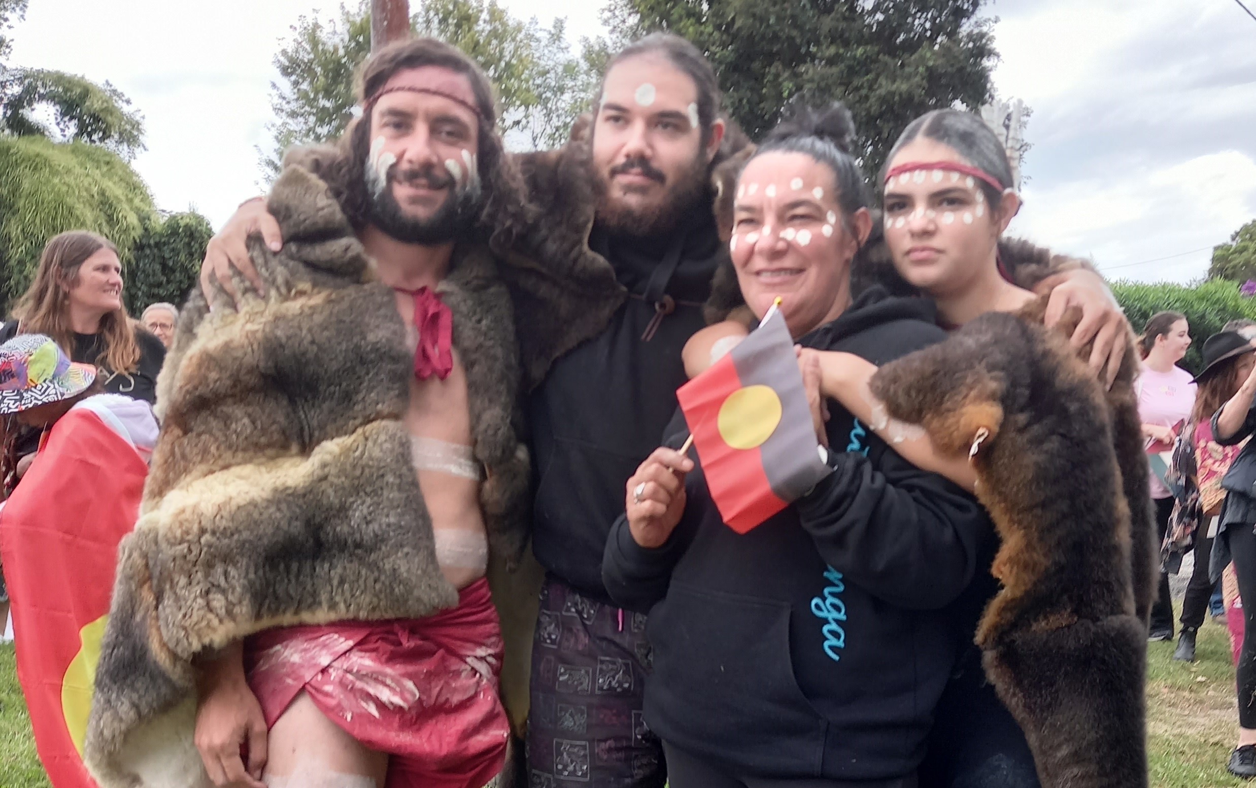 Four people dressed for Aboriginal ceremony.