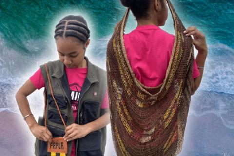 A young West Papuan woman sports the Noken bag, wearing it around her shoulder and around her head.