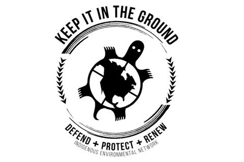 A black and white image of the Indigenous Environmental Network logo which depicts a turtle carrying north and central America on its back. Surrounded by a circular indigenous design with lines and arrowhead symbols—as well as the logo text, which says ‘Keep it in the ground. Defend + protect + renew. Indigenous Environmental.’ 