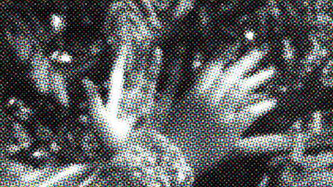 black and white pixelated image of hands crossing each other. Swirls surrounding the hands.
